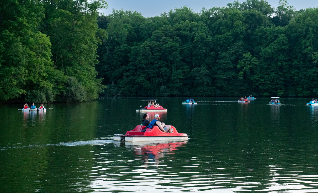 people in a pedal boat on a lake