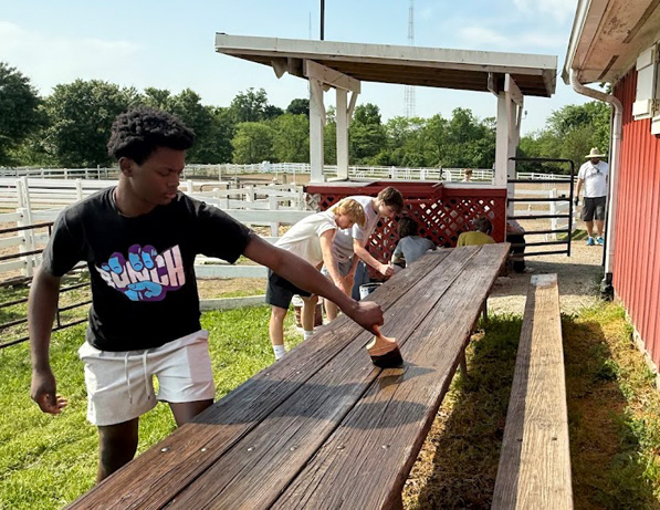 a group of people painting a picnic table