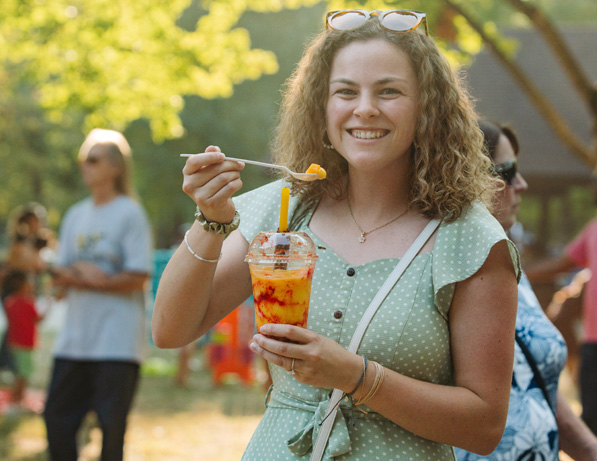 a woman holding a spoon and a drink