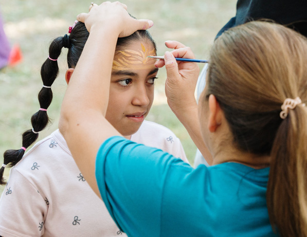 a woman painting a girl's face