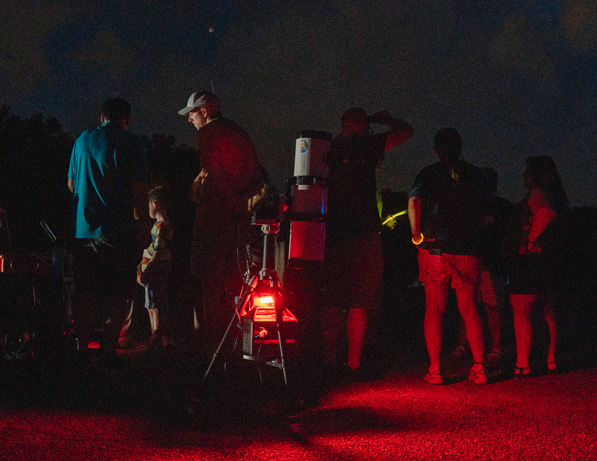 a group of people standing around a red light